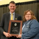 Dianna Beeler receives an award from Robert Hinde at the 2023 Faculty Awards Convocation