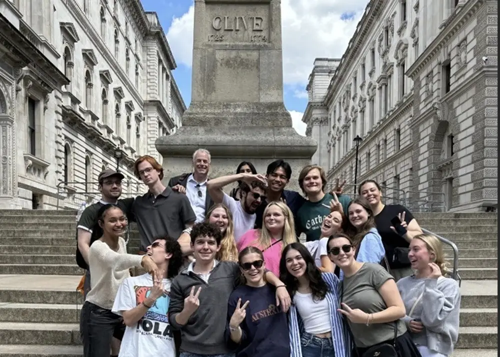 A gorup photo of students on steps in front of old architecture in London