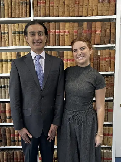 A man and a woman posing for a photo together in front of a large bookshelf
